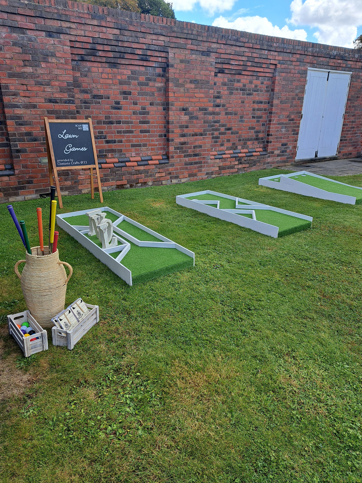 White wedding golf holes on a grassy area within a walled garden. The Villa Wrea Green