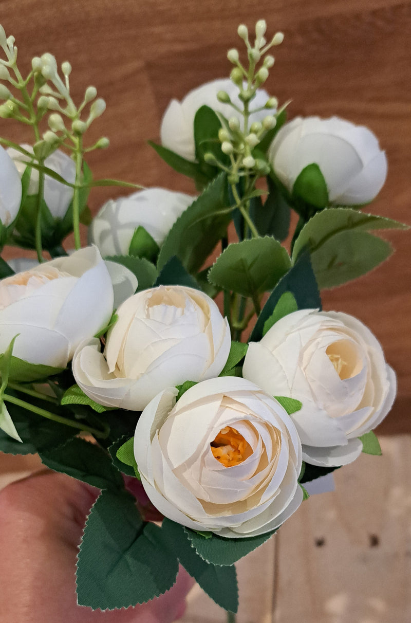 Blush peonies with green foliage on a wooden background